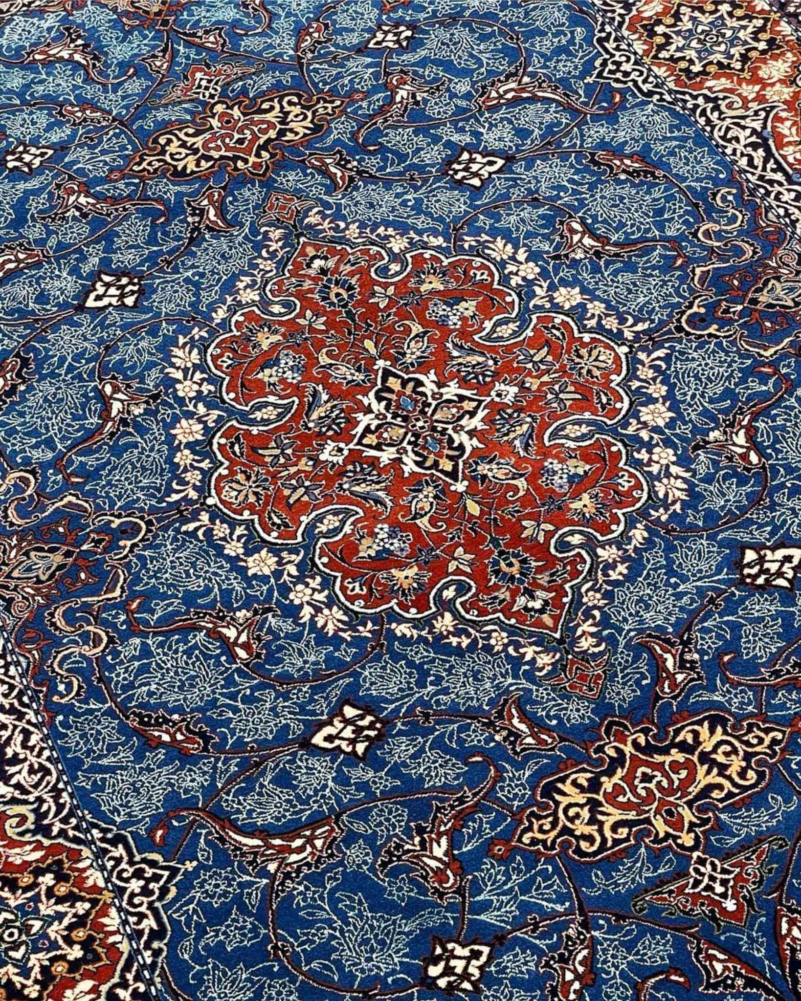 Authentic Persian carpet with rich red borders and detailed floral motifs.